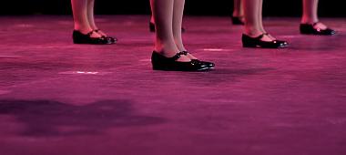 Dancers on stage during a recital in bright costumes. Noise reduction was applied on the floor and the dancers in the background but not ...